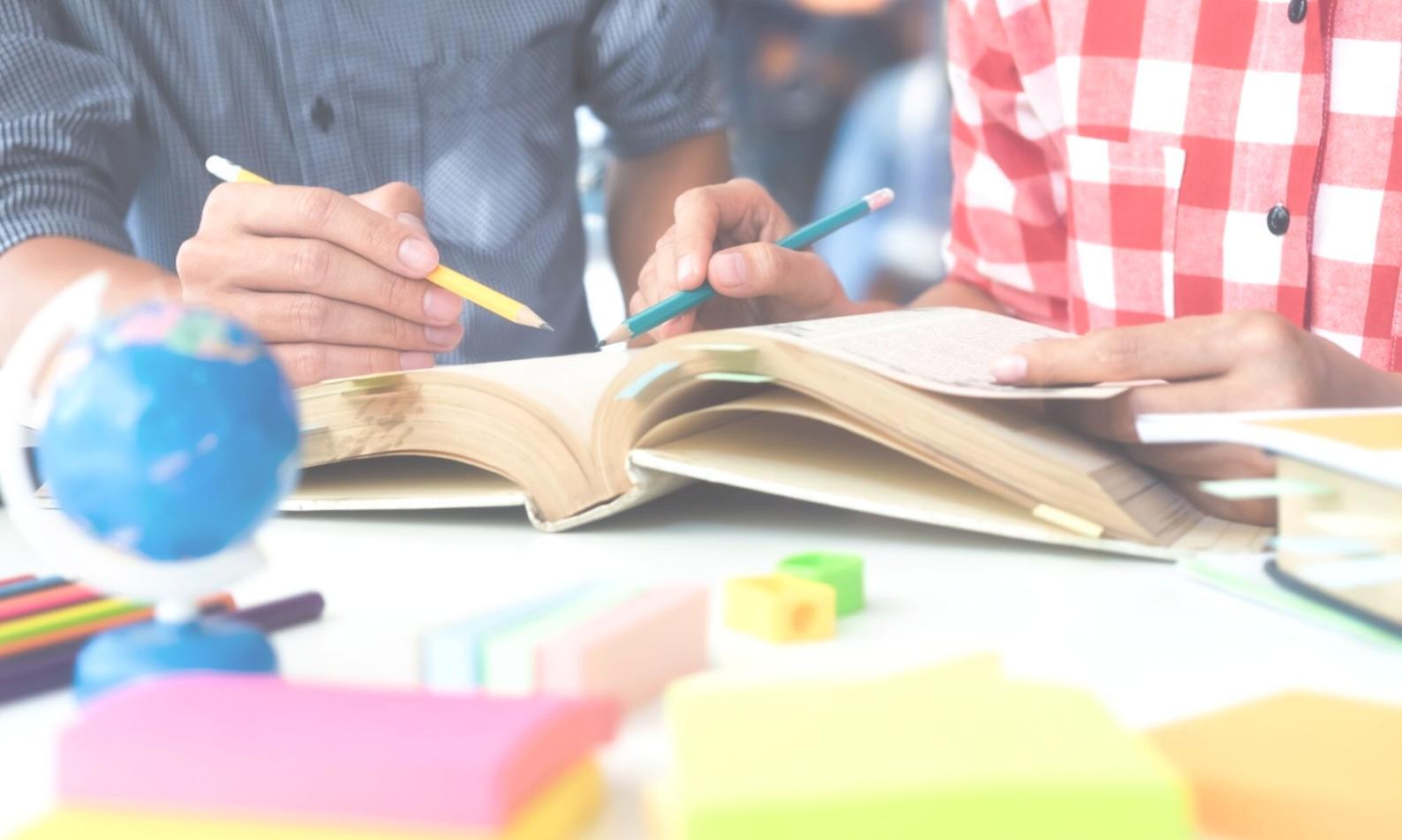 Students analyzing financial data on multiple screens during a live market session